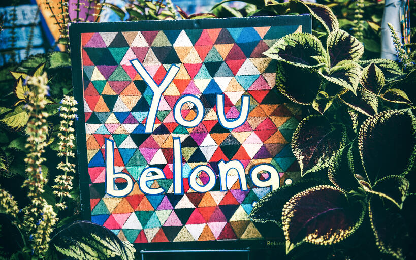 Colourful image saying you belong here, surrounded by lush foliage