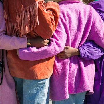 Colourful image of friends with arms around each others back